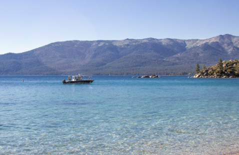 The University of Nevada, Reno R/V Liberty research vessel floats on blue waters with scenic mountains in the background.