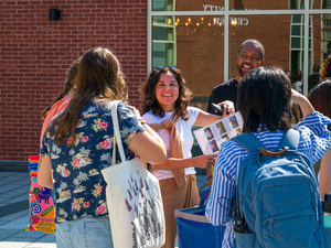 Group of international students and their families meet up for their tour, some holding campus maps.