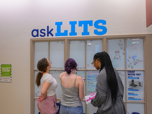 Students read from a message board, text above reads "Ask LITS"