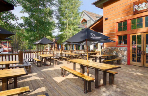 Kickapoo Tavern patio with tables, benches and umbrellas
