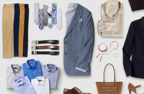 Shirts, belts, watches and slacks, layed and folded on a table.