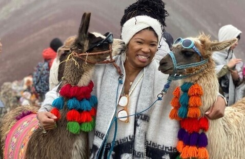Student studying abroad pets and holds two llamas 