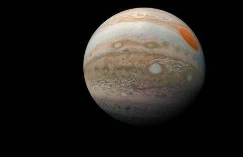 The planet Jupiter, floating in the cold, black void of space.