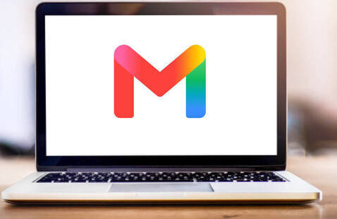 Laptop displaying Gmail logo centered on white screen