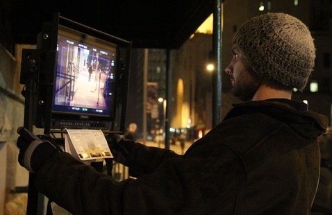 man viewing a film camera monitor 