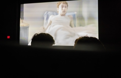 people watching a movie screen in a theater