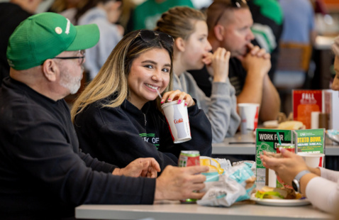 Student enjoying a soft drink with family during welcome weekend brunch 2025.