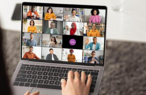A hand on a laptop keyboard during Zoom meeting