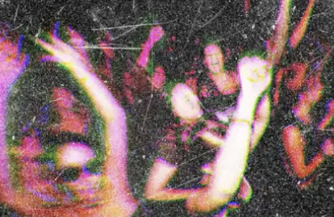 Blurry film photo of people raving in a club 