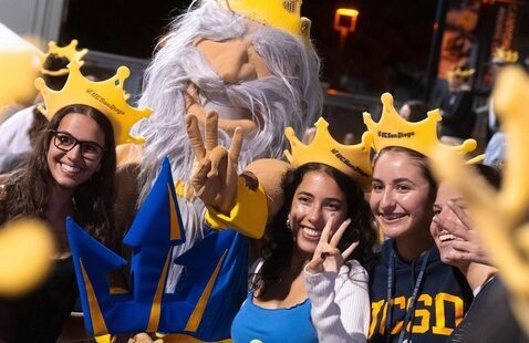 Group of people wearing foam Triton crowns taking photo with King Triton mascot