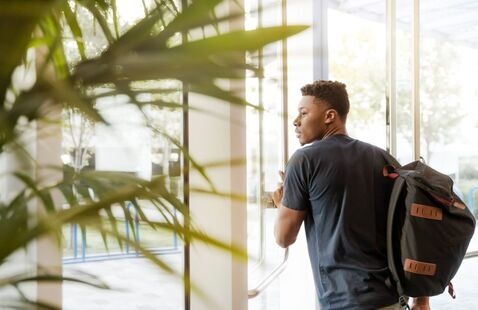 college student walking through a door