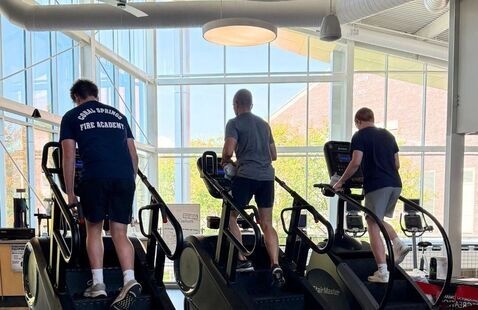 3 people climbing on StairMaster machines