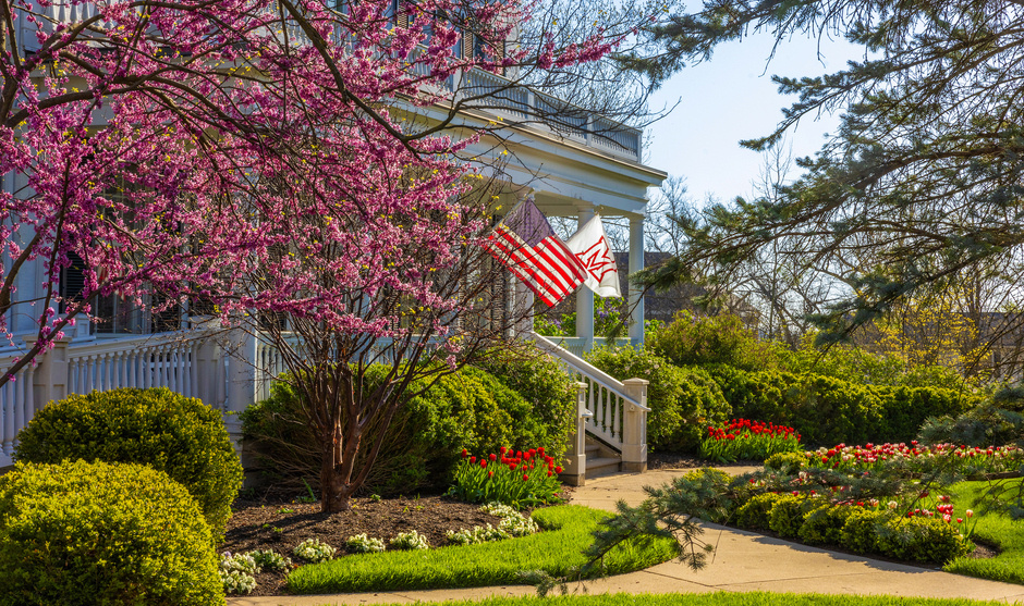 Lewis place front porch in spring with American flag and Miami flag