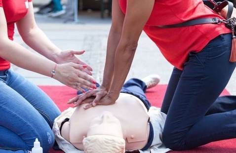 Two people performing CPR on a manikin