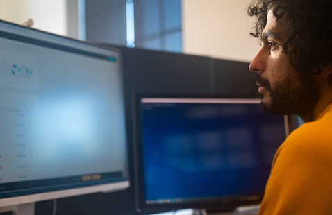 A photo of a man looking at a computer