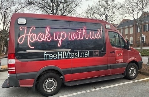 Red STI testing van with wording on the side that says, "Hook up with us!" freeHIVtest.net