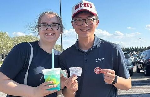 Happy customers with giveaway tokens and market drinks!