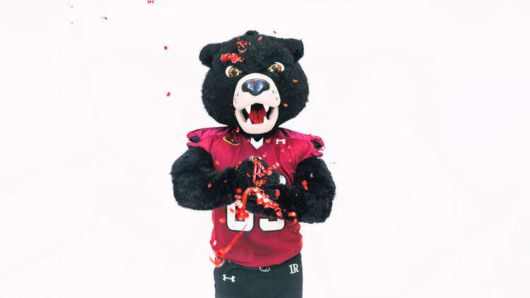 Joe Bear mascot throwing confetti