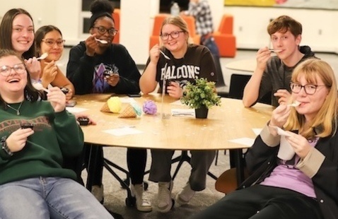 Six students sitting at a table enjoying ice cream