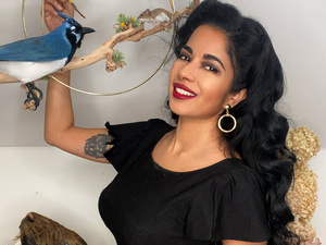 artist with taxidermy blue jay, mouse, and big cat