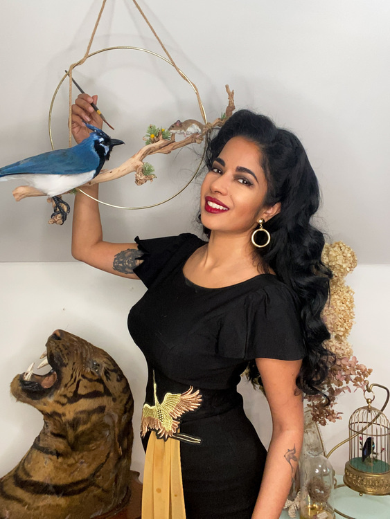 artist with taxidermy blue jay, mouse, and big cat