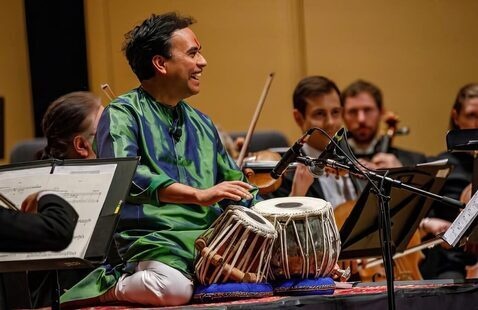 Performer plays drums with the symphony