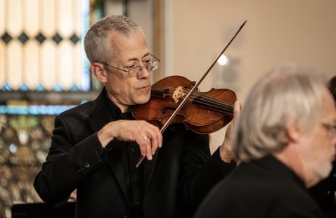 A man playing violin intently 