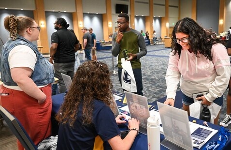 students chatting with program reps at UTC grad fair 
