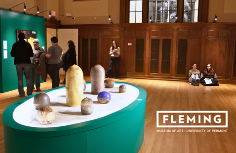Green oval exhibit of ceramic sculptures on sand in gallery; visitors nearby; FLEMING MUSEUM OF ART | UNIVERSITY OF VERMONT