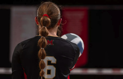 Volleyball player facing away from the camera, #6 on the back of her jersey.