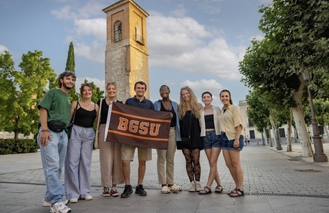 students in Spain holding a BGSU flag
