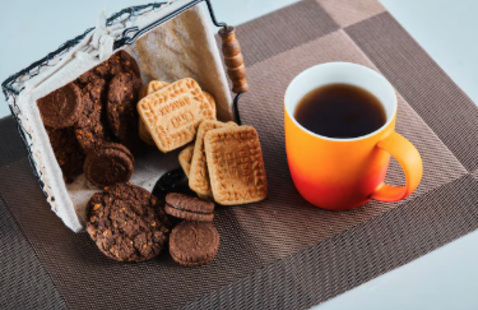 A cup of coffee and snacks laid out on a table