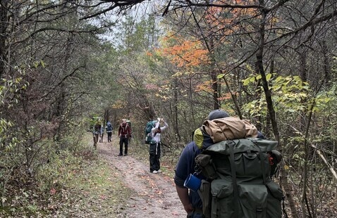 hiker on trail with fall leaves