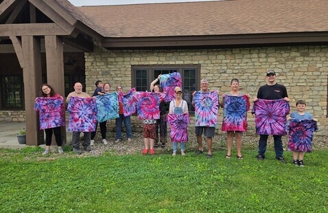 group of people showing off tie dyed t-shirts