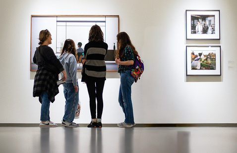 Four people viewing artwork