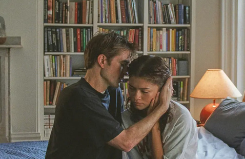 Two people hugging in a room with large book shelves