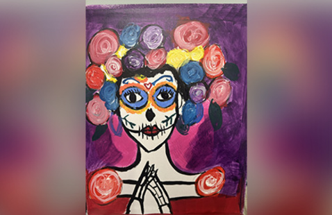 Person with sugar skull face paint and colorful flower crown on purple background, hands clasped