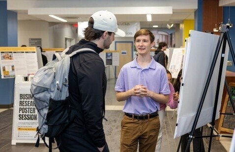 Two students discussing research poster in Peacock Hall
