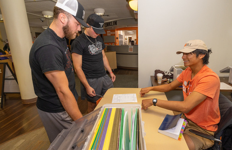 A resident advisor talking to other students within the resident hall 