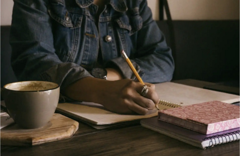 Photograph of a person writing.