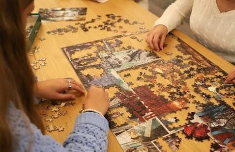 Two people puzzling at a table