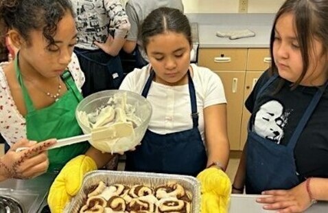 Three children baking cinnamon rolls