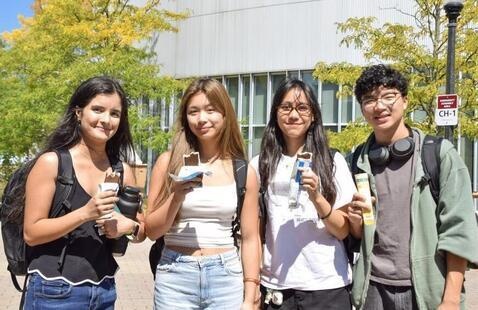 Four Honors College students holding ice cream standing outside