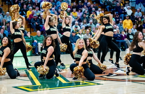 The UVM Dance Team performing during halftime at a men's basketball game.
