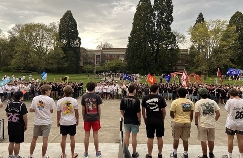 Men in t-shirts and shorts lined up in the Quad