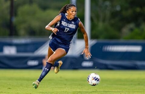 Female soccer player kicking the ball 