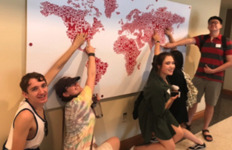 students pointing to their hometowns on Miami map