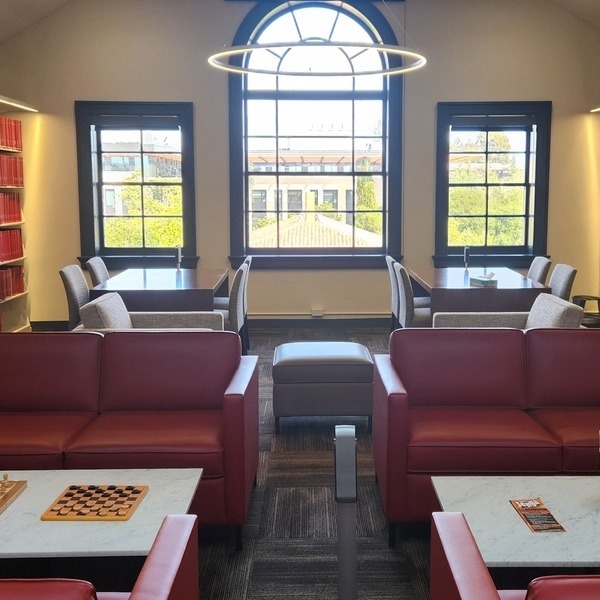 Li & Ma Science Library 4th Floor with red sofas, study tables, arched window, bookshelves. Photo by Aparna Sharma.