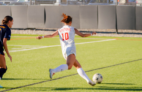 Soccer player kicks ball
