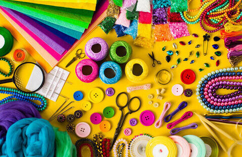 A yellow background full of colorful crafting supplies.